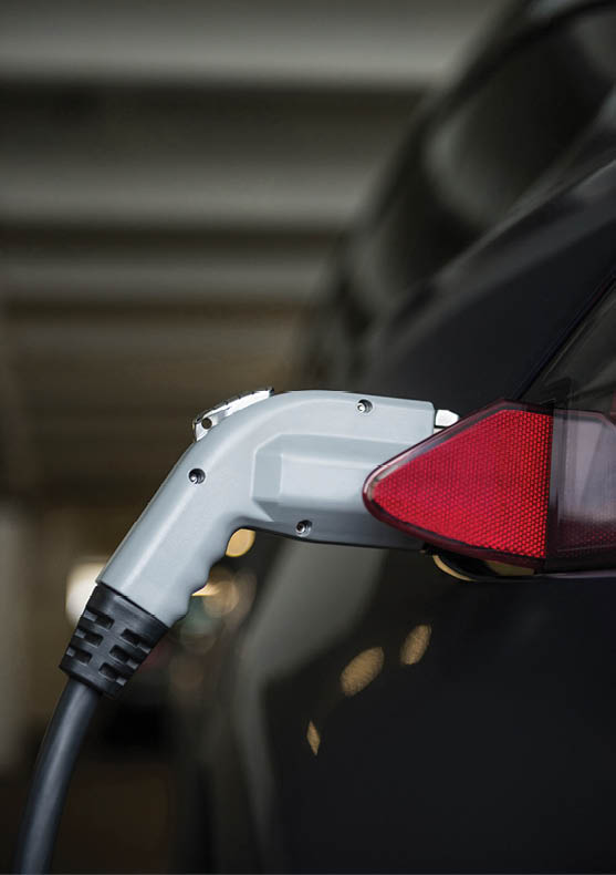 Close-up of car being charged with electric car charger at charging station